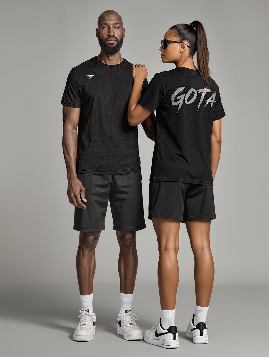 Two people wearing the black GOTA tee, front and back