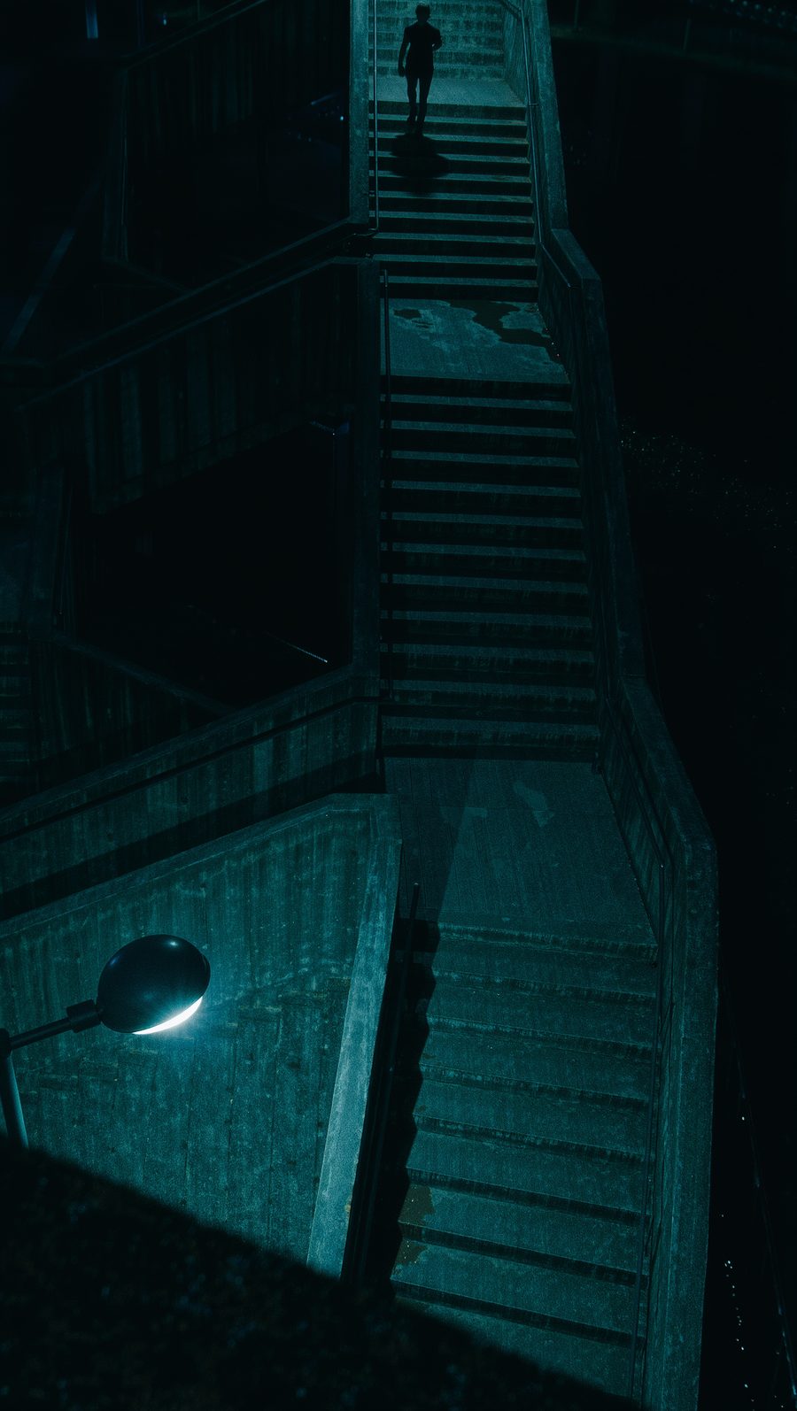 A figure at the top of a dark stairwell